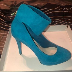 There are a peacock green high heel